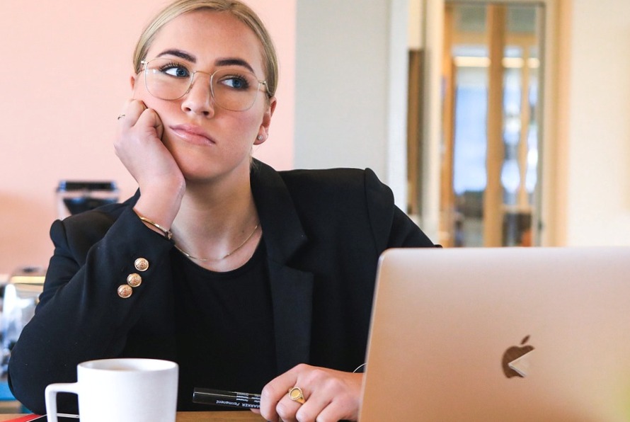 Business woman at a laptop looking thoughtful