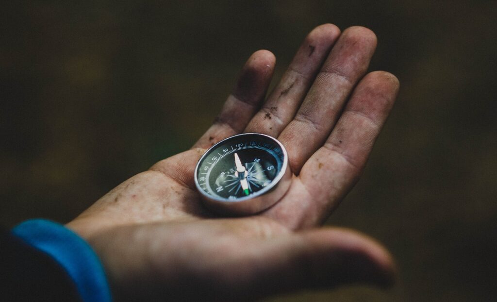 A hand holding a compass