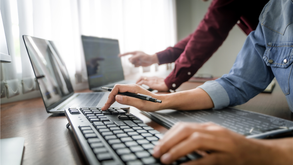 Two people using three computers